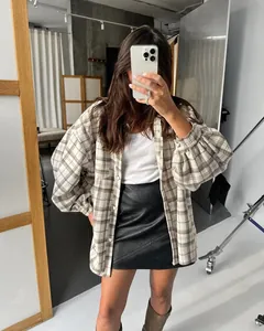 Oversized vintage plaid shirt for women styled with a black leather skirt in a studio.