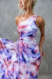 Detail view of elegant one-shoulder floral pleated dress with vibrant purple prints.