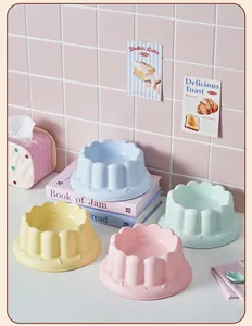 Detail view of colorful scalloped edge elevated pet bowls in a home setting