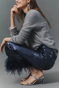 Detailed side view of elegant navy blue sequin trousers with luxurious ostrich feather trim