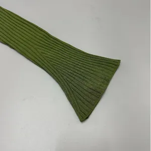 Macro view showing the detailed green ribbed flare sleeve of this knitted cardigan