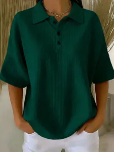 Close-up of dark green waffle knit polo shirt with buttoned collar and short sleeves
