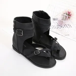 Close-up detail of black gladiator sandals featuring buckle straps and side zipper closure