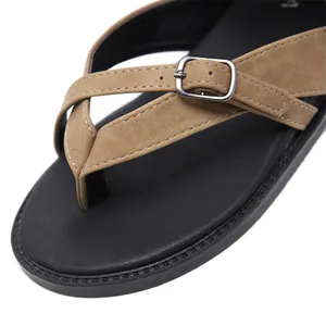 Detail view of women's Roman sandals with brown cross straps and a soft black footbed.