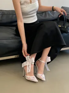 Detailansicht weißer Mesh-Stiletto-Sandalen mit Spitze und großer Schleife am Knöchel