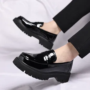 Dichtbij van heren glanzende zwarte lakleren loafers met dikke profielzolen en stijlvol ontwerp.