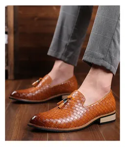 Detailansicht stilvoller brauner Herren-Loafer mit Quasten und gewebter Textur.
