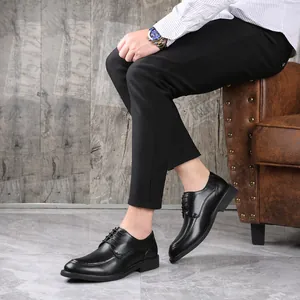 Detailed side view of sleek black lace-up business leather dress shoes on a seated model