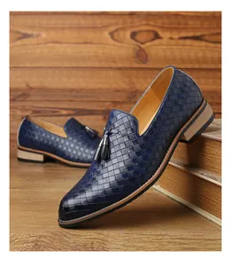 Detailansicht der marineblauen Slipper aus geflochtenem Leder mit schwarzen Quasten.