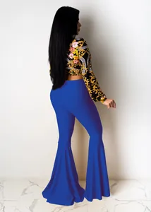 Detailed view of bright blue high-waisted bell bottom pants with baroque print crop top