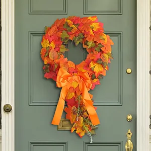 Vibrant autumn maple leaf door wreath with a large orange ribbon bow for fall decor