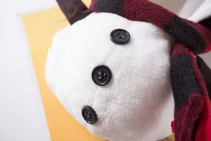 Detailansicht des weißen Plüsch-Schneemann-Haustierkostüms mit Knöpfen und Karo-Schal.