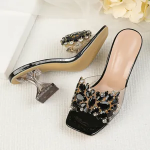 Detailopname van elegante strass-sandalen met transparante banden en kristallen hak
