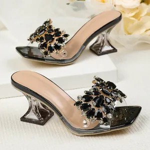Detailweergave van strass-sandalen met transparante vierkante kristallen hakken
