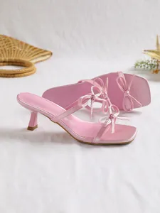 Nahaufnahme eleganter rosa Kitten-Heel-Sandalen mit quadratischer Zehenpartie und Schleife.