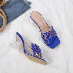 Elegante detailweergave van blauwe sandalen met stras en transparante kristallen hak