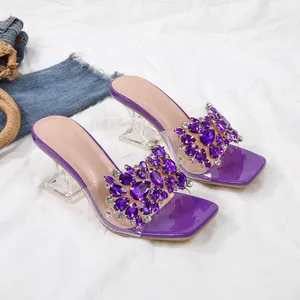 Detailweergave van paarse strass sandalen met elegante transparante kristallen blokhakken