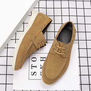 Detail view of men's tan suede boat shoes showing minimalist stitching and lacing