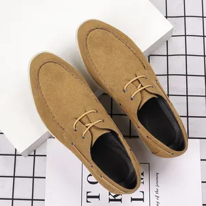 Top view of camel suede loafers on white minimalist display stands