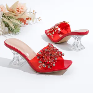 Detail van rode slippers met strassteentjes en transparante kristallen hak.