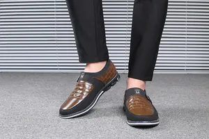 Λεπτομερής προβολή ανδρικών casual slip-on σε καφέ και μαύρο με ανάγλυφο σχέδιο πλέγματος