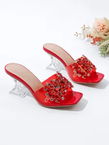 Detailopname van elegante rode strass sandalen met transparante geometrische kristallen hakken