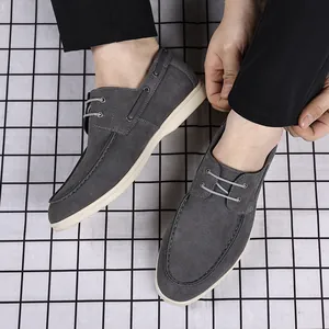Top view of stylish men's grey suede loafers with durable white soles and laces