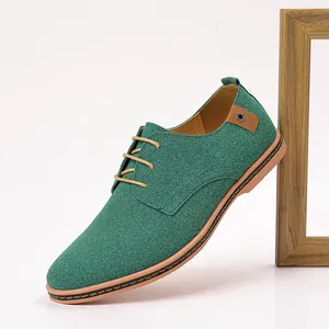 Close-up detail of a stylish green suede men's casual dress shoe with laces and wood frame