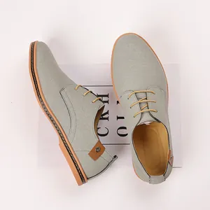 Detailed view of grey suede men's casual lace-up shoes with brown decorative heel tab detail.
