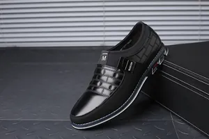 Λεπτομέρεια μαύρου ανδρικού slip-on loafer με ανάγλυφη επιφάνεια και ετικέτα μόδας