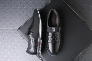 Κάτοψη και πλάγια όψη μαύρων ανδρικών casual loafers πάνω σε μαύρο χαρτοφύλακα για καθημερινή χρήση