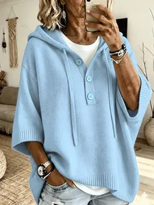 Détail du pull en maille à capuche bleu clair avec patte de boutonnage et manches