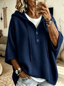 Détail du pull à capuche en maille bleu marine avec boutons décoratifs et coupe ample.