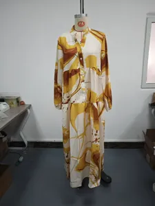 Full-length view of a yellow abstract print long-sleeved maxi dress on a mannequin