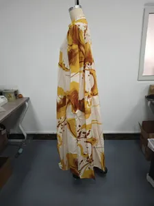 Profile view of a yellow abstract print long-sleeved loose maxi dress on a mannequin