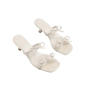 Elegantes sandalias crema con tacón de gatito, punta cuadrada y diseño de doble lazo