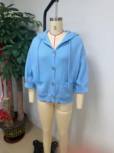 Detailed macro view of a light blue knit hooded cardigan jacket on a professional mannequin