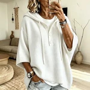 Pull à capuche en maille blanche pour femme avec boutons dans un cadre de vie décontracté.