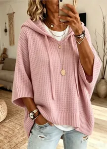 Détail d'un pull à capuche rose en maille gaufre avec une coupe ample et décontractée