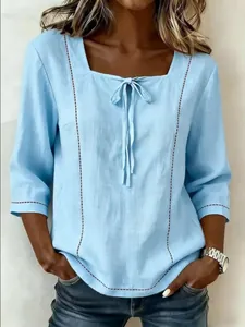 Detailansicht der hellblauen Bluse mit Karree-Ausschnitt, Bindeband und Print