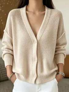Detailed view of beige hollow-out knit cardigan with V-neck and buttons