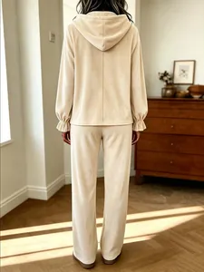 Rückansicht eines beigen Samt-Lounge-Sets mit Kapuzenpullover und entspannter Hose.