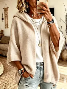Détail d'un cardigan beige en tricot à capuche avec manches 3/4 pour femmes