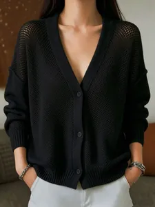 Close-up of black hollow knitted cardigan with V-neck and button closure details