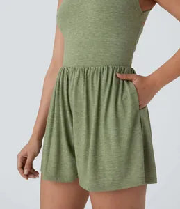 Detail of green sleeveless romper showing pleated waist and functional side pocket.