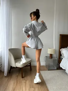 Vista trasera de modelo con conjunto de sudadera corta gris y pantalones cortos.
