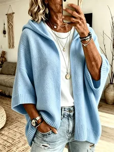 Détail d'un cardigan en maille bleu clair à capuche avec manches 3/4 et texture douce