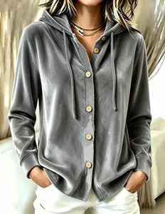 Détail d'une veste à capuche en velours gris avec boutons en bois et coupe ample.