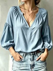 Élégant chemisier bleu clair à col en V plissé et manches lanternes pour femmes.
