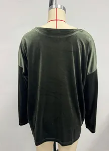 Close-up back view of luxury velvet long-sleeve top in emerald green and black
